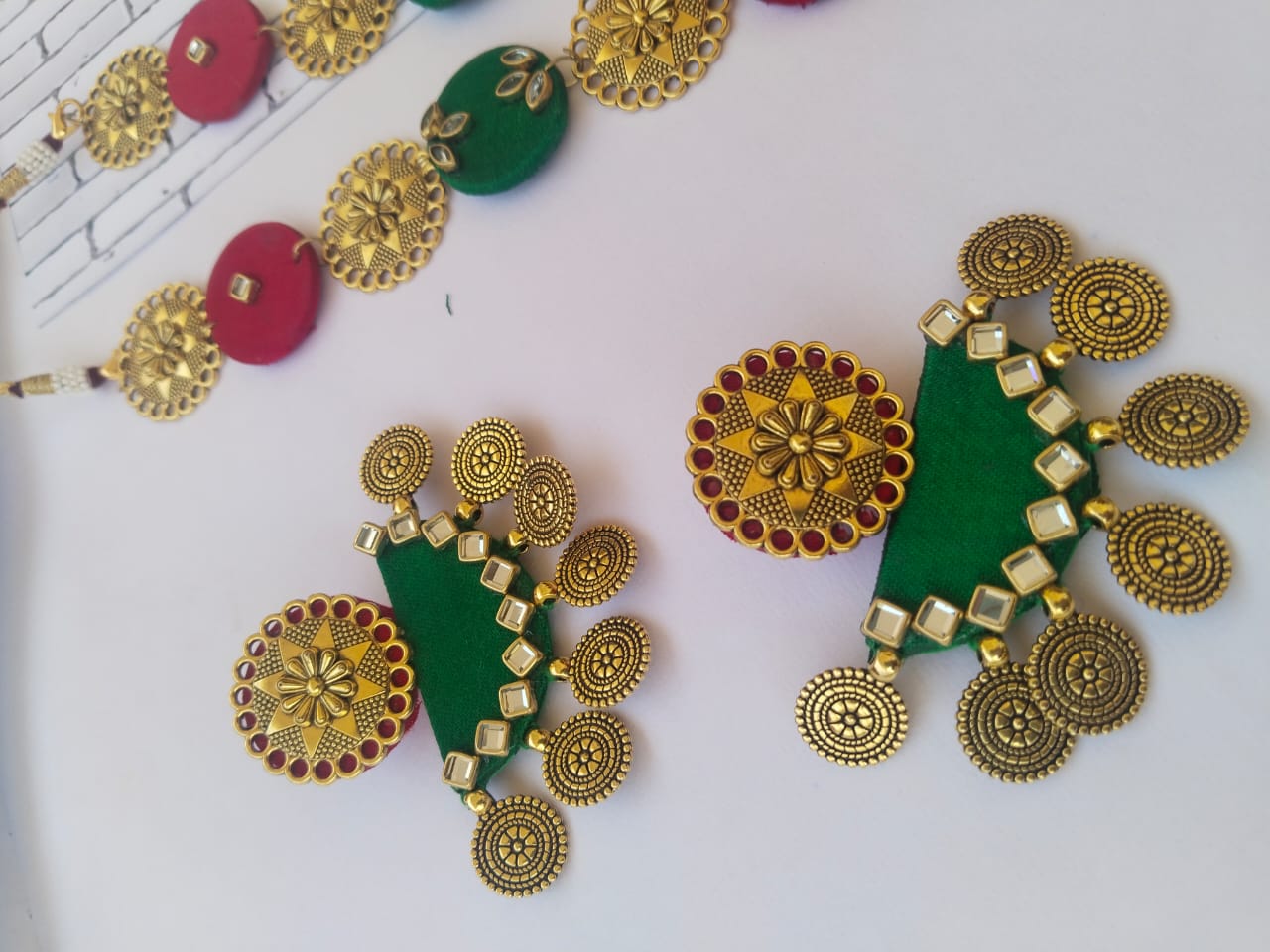 Green and golden kundan earrings with coins on white backdrop