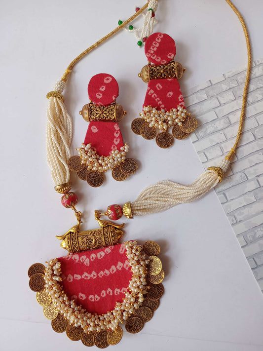 Red bandhani printed necklace with golden tabiz, coins and white beads on white backdrop
