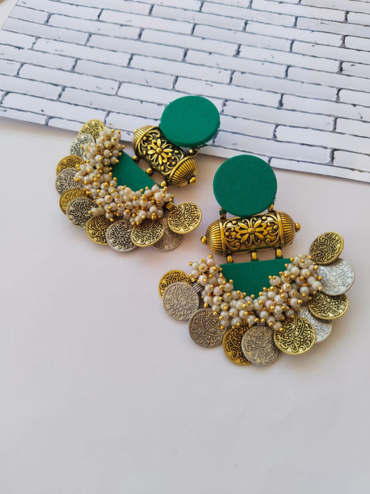 Sea green jhumka earrings with golden tabiz, white beads and golden silver coins on white grey backdrop
