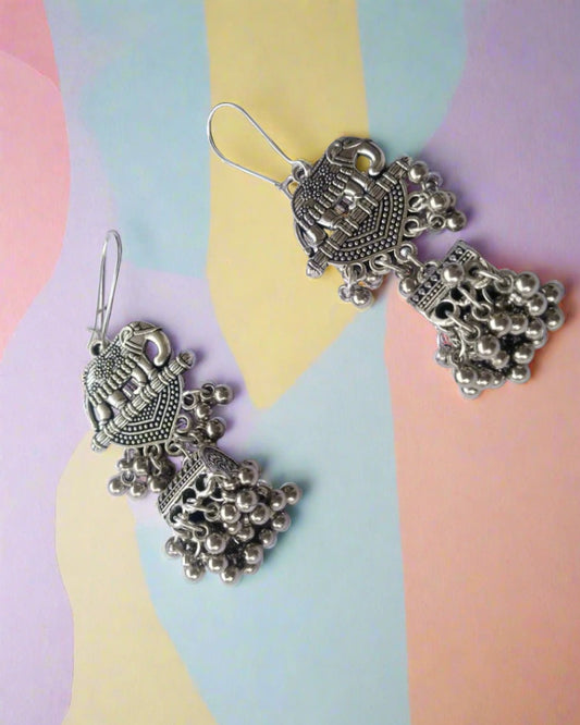 Silver oxidised earrings with elephant charm and ghungroos on white backdrop