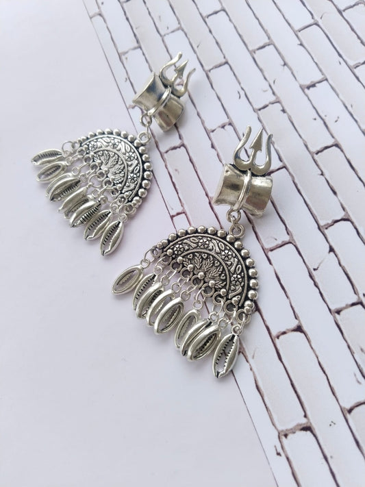 Silver oxidized semi round jhumka earrings with silver beads and trishul charm on white backdrop