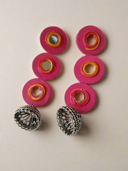 Three layered round pink long earrings with silver bottom on white backdrop