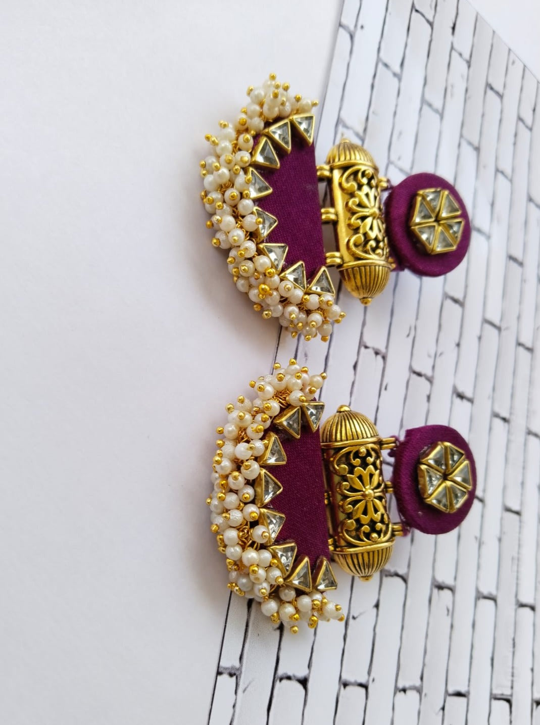 Wine purple earrings with golden beads and tabiz on white backdrop