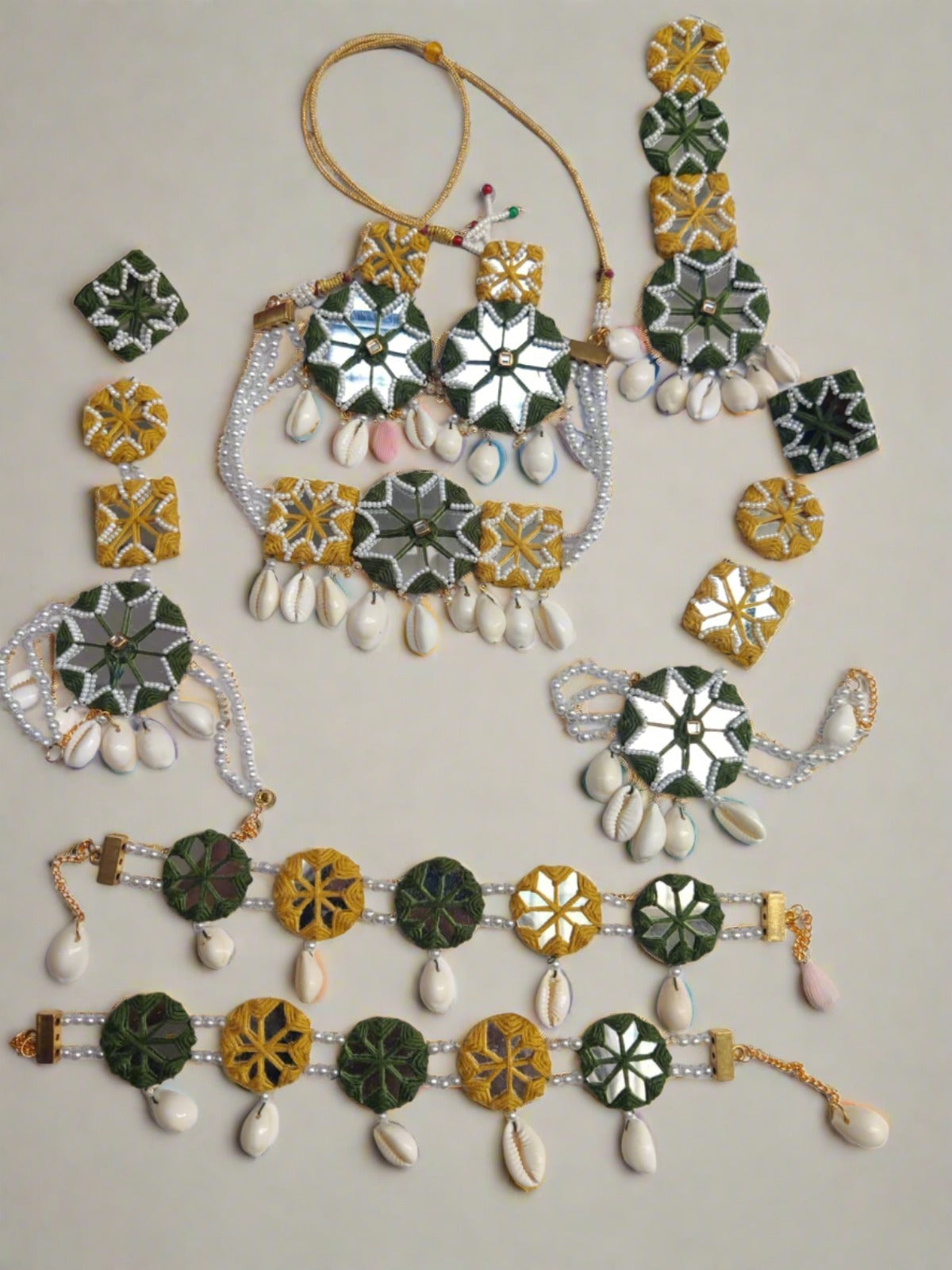 Yellow and green mirror necklace, bracelet, earrings, tika and anklet set on white backdrop