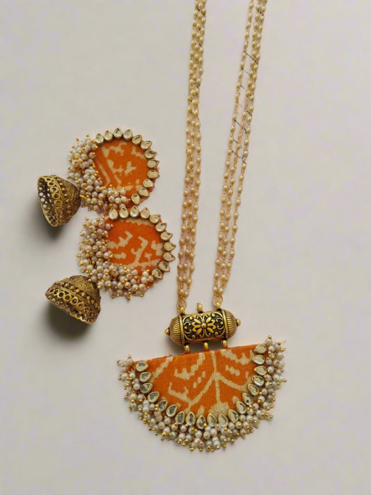 Yellow orange patola printed necklace with golden beads and matching earrings on white base