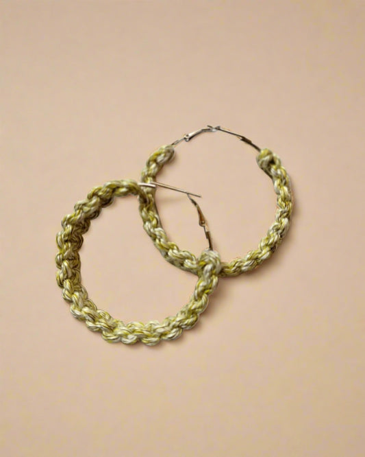 Green crochet knitted hoops earrings on white backdrop